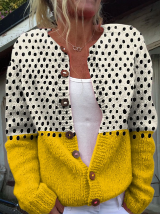 Junella cardigan worn open over a white top, showing the polka-dot upper and mustard sleeves
